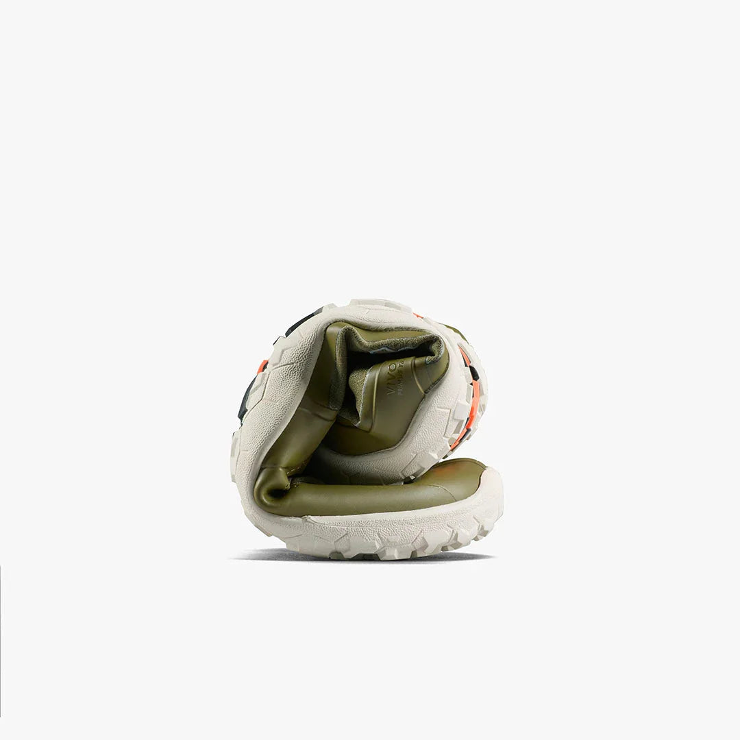 Flexible white and olive hiking shoe rolled to show sole and inner padding with orange accents