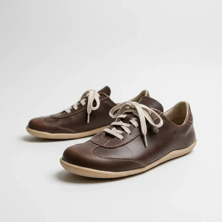 Brown minimalist barefoot shoes with cream laces on white background, eco-friendly footwear