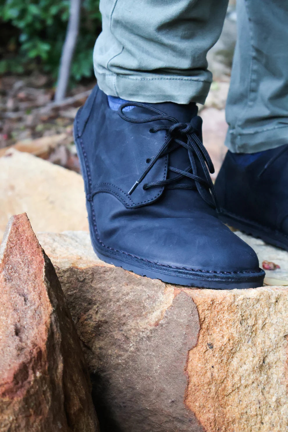 Black booties worn by a person standing on a rock