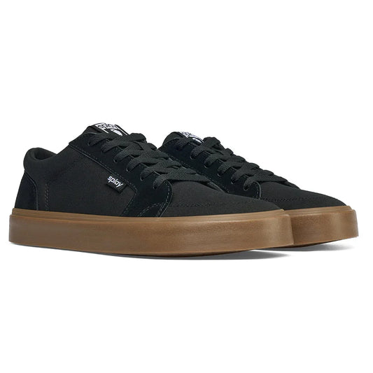 Black canvas sneakers with brown rubber soles and black laces, side view