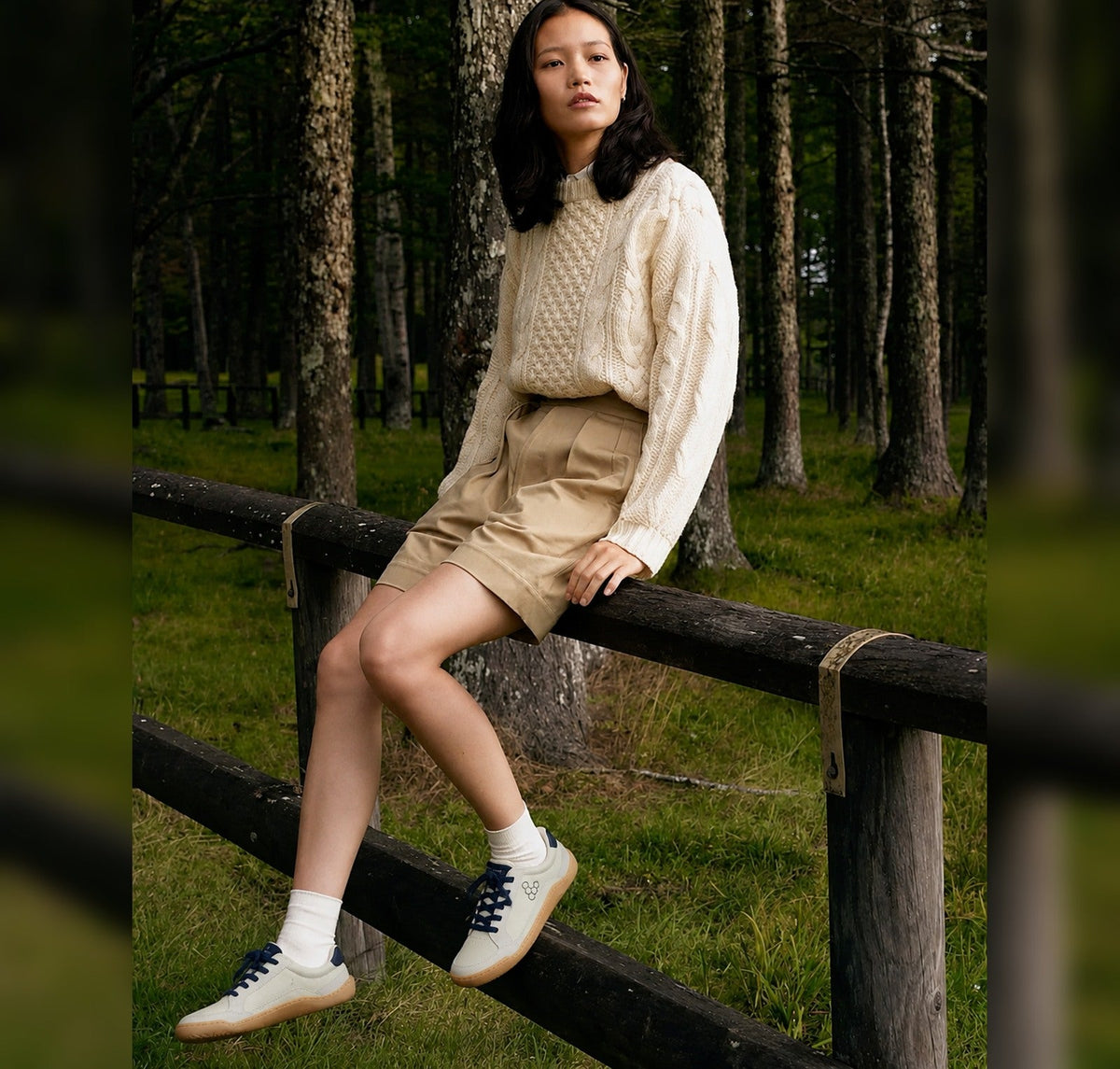 Woman wearing sustainable barefoot sneakers and ripped jeans sitting urban outdoors