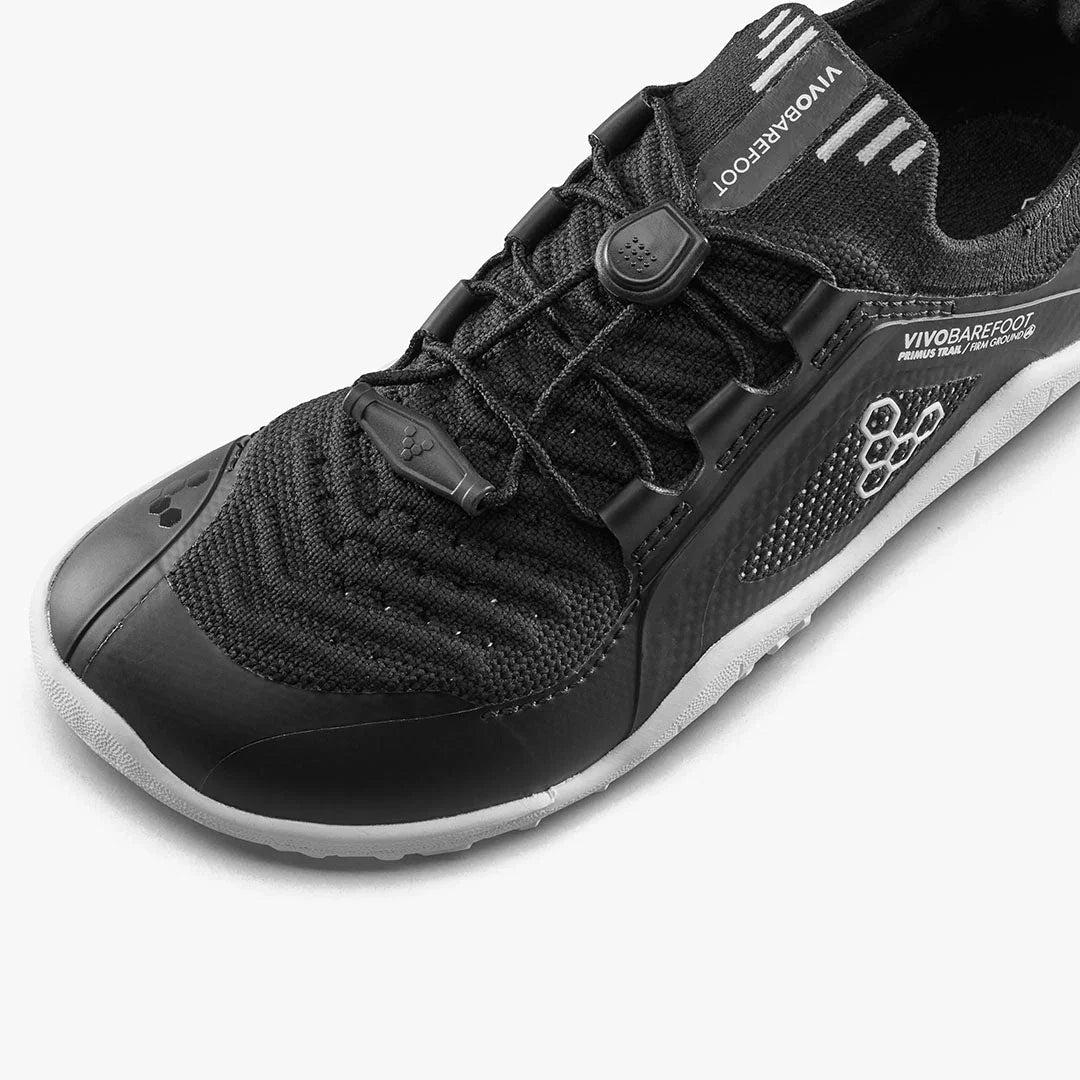 Close-up of black Vivobarefoot Primus Trail athletic shoe with mesh upper and secure elastic lacing