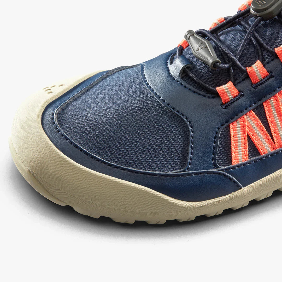 Closeup of navy blue and beige sneaker with orange accents and durable rubber sole