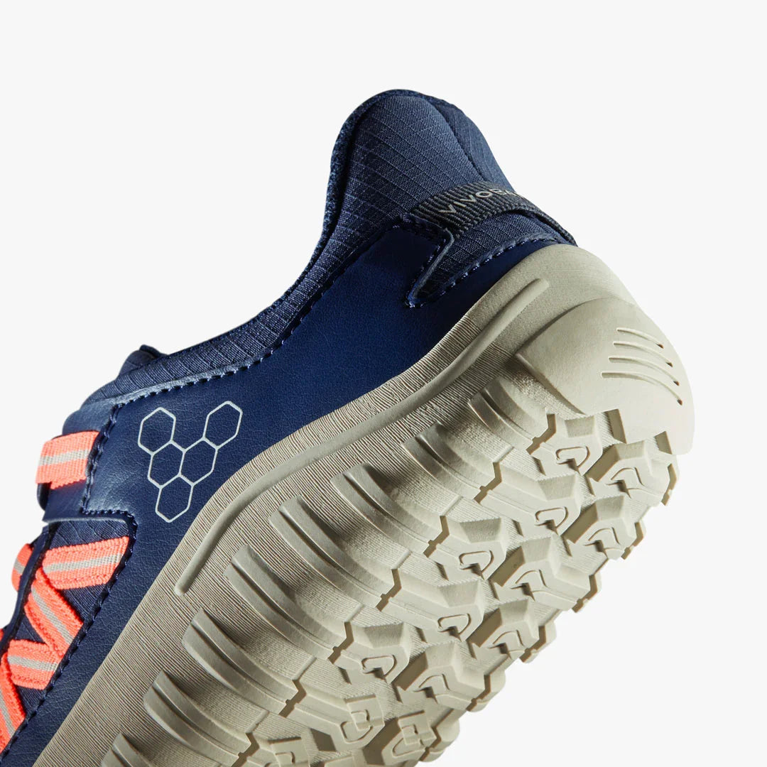 Close-up of navy blue and coral athletic shoe sole with textured grip and brand logo
