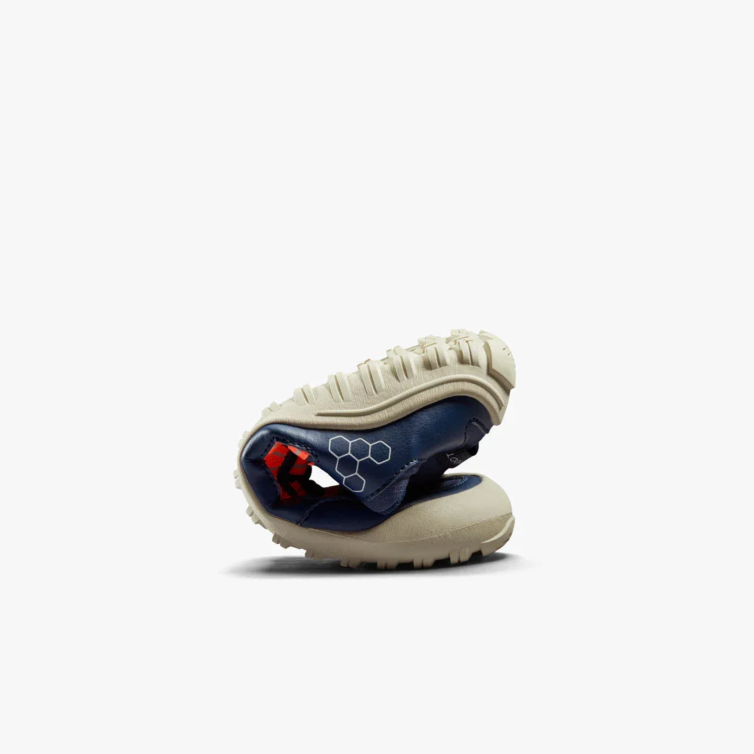 Flexible beige sole hiking shoe curled to demonstrate bendability on white background