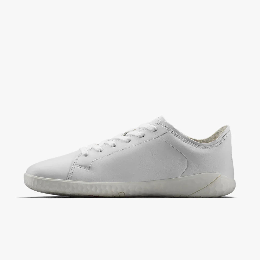 Minimalist white leather sneaker with lace-up front and textured sole on white background