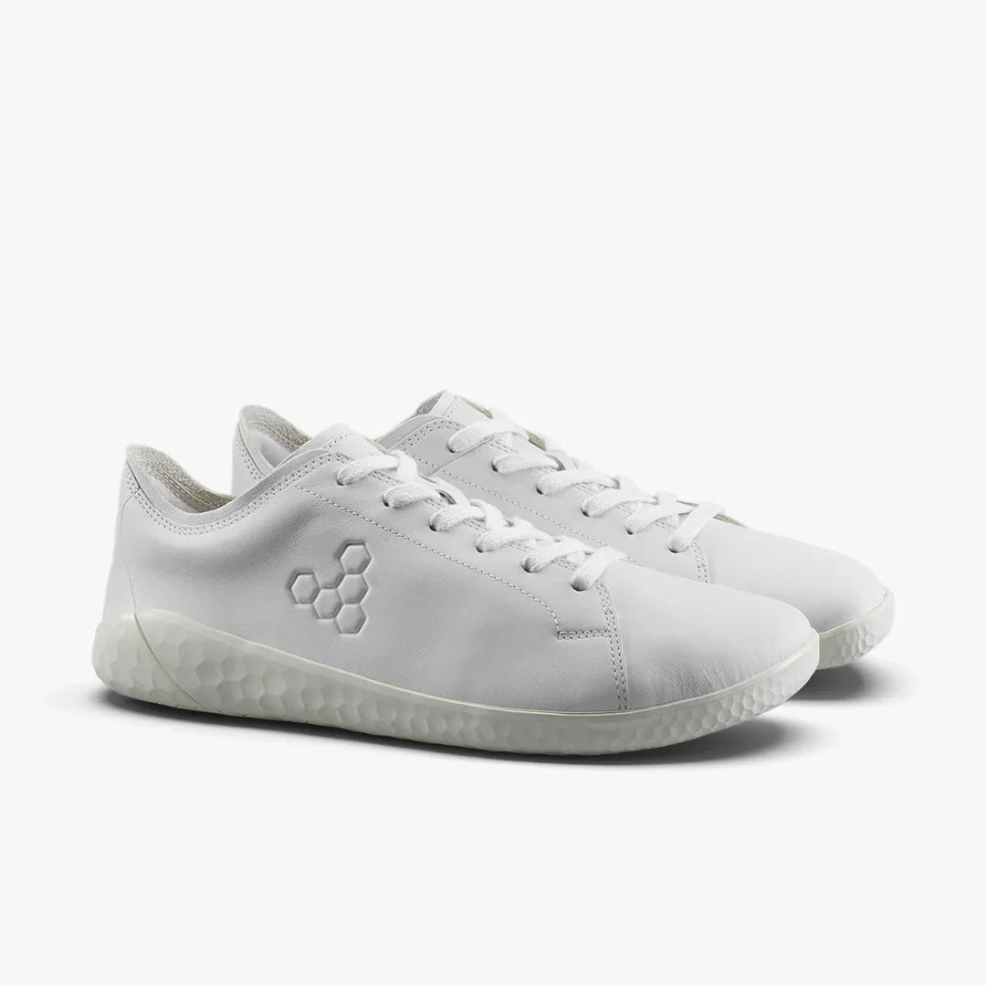 Pair of minimalist white leather sneakers with hexagonal logo and textured rubber sole