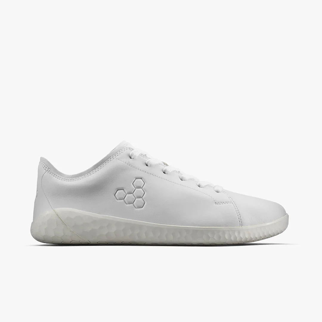 Side view of all-white minimalist sneaker with hexagonal embossed logo and textured sole