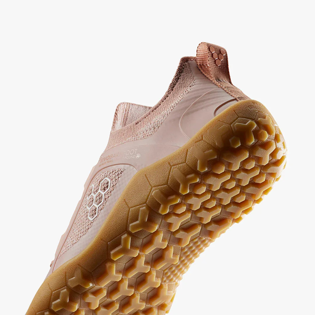 Close-up of pink Vivobarefoot barefoot trail running shoe with hexagonal tread sole pattern