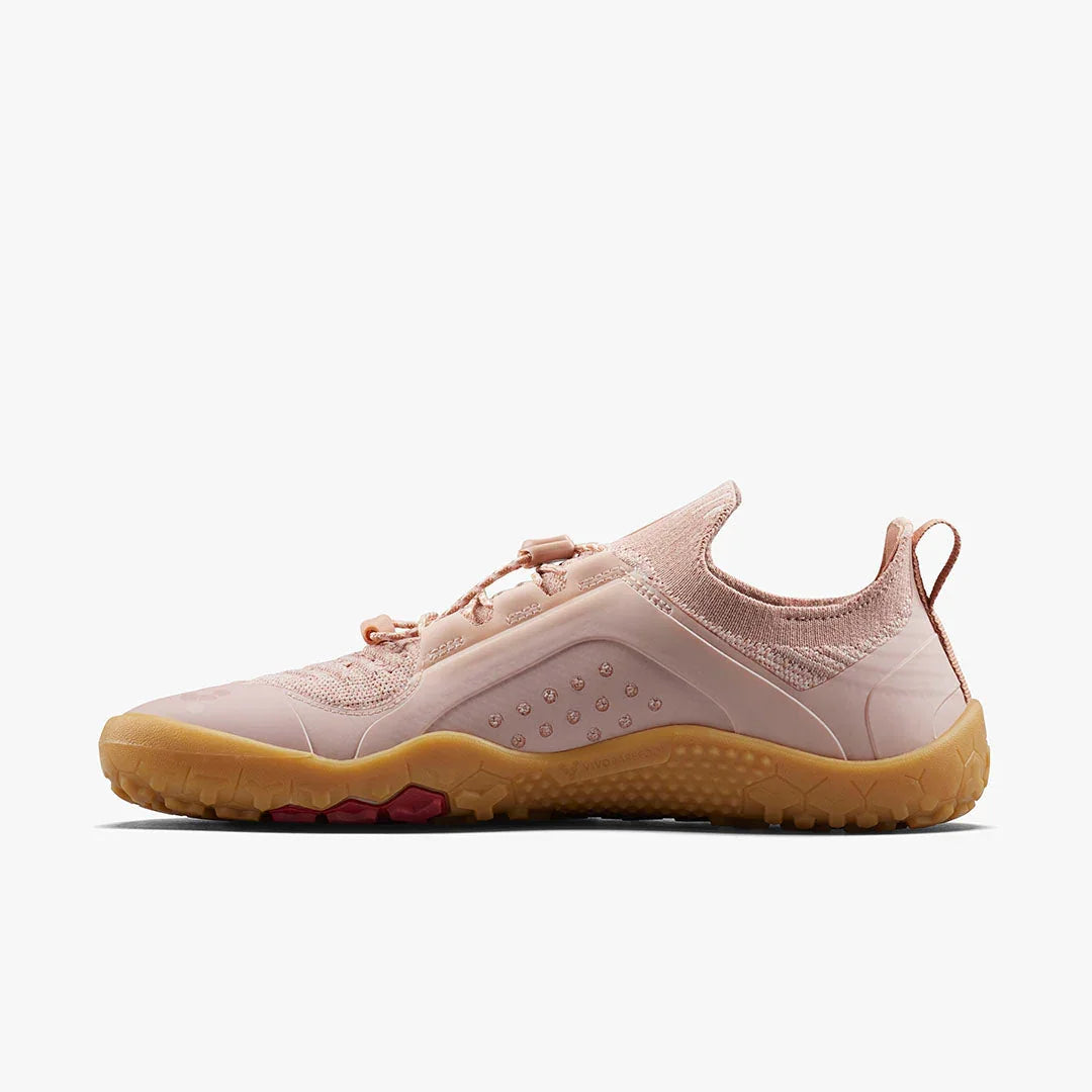 Light pink sneaker with knitted upper and tan rubber sole on white background