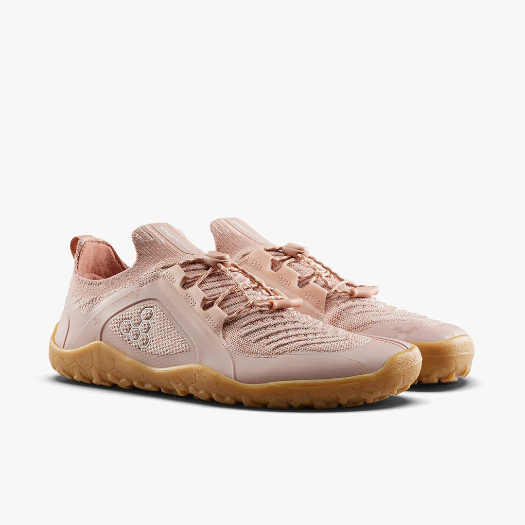 Pair of light pink knit knitwear shoes with brown rubber sole, minimal laces, and honeycomb logo