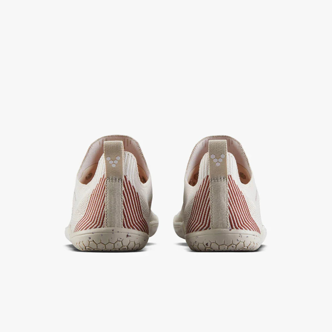 Back view of beige slip-on minimalist shoes with red stripes and hexagonal sole pattern