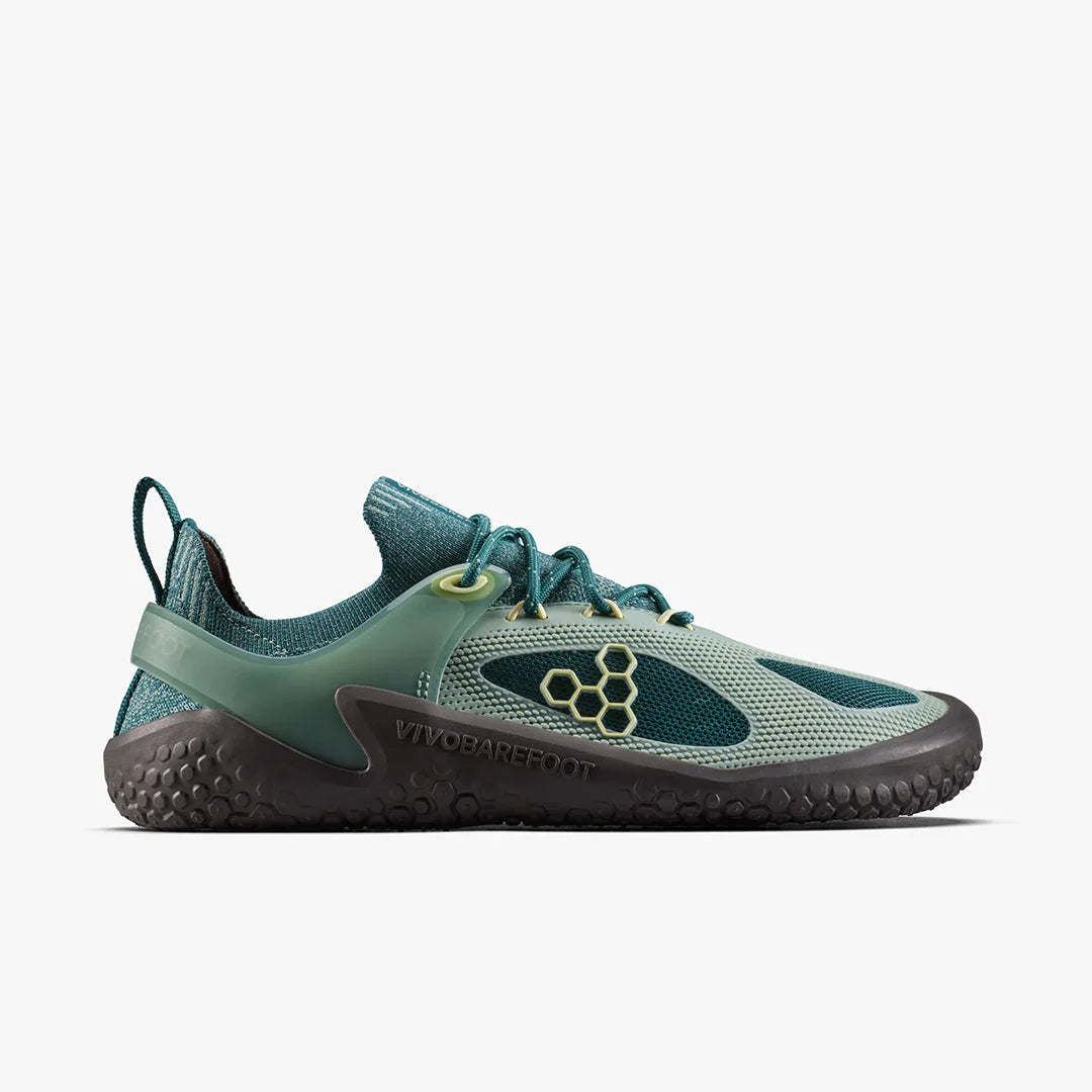 Side view of green and black Vivobarefoot minimalist athletic shoe with honeycomb logo and textured sole