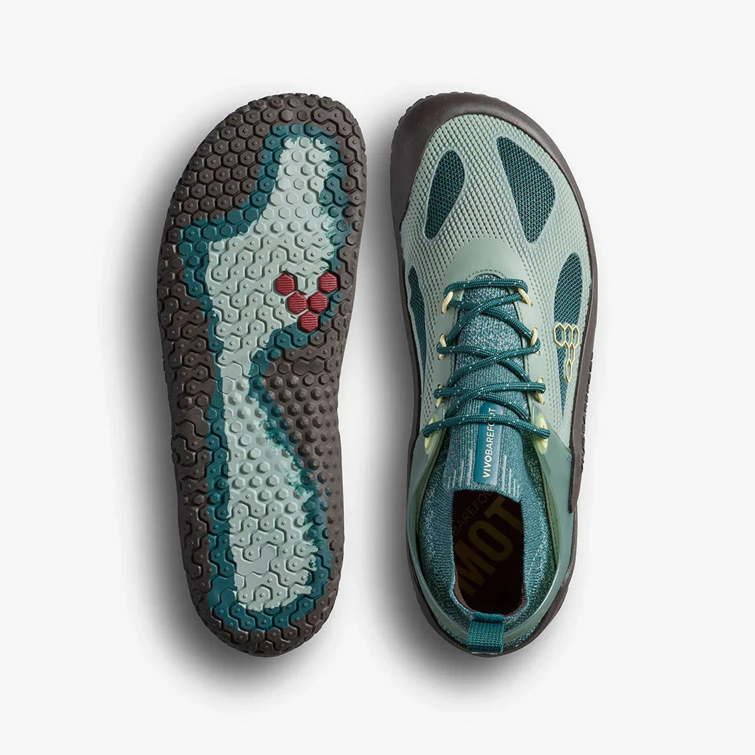 Top view of green and teal minimalist barefoot running shoes with textured soles on white background
