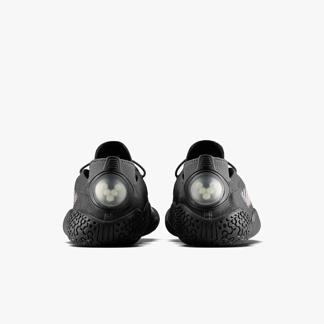 Back view of black athletic shoes with textured soles and translucent circular heel details