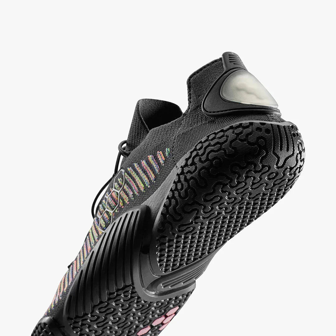 Close-up of black athletic shoe sole with textured tread and multicolor knit upper design
