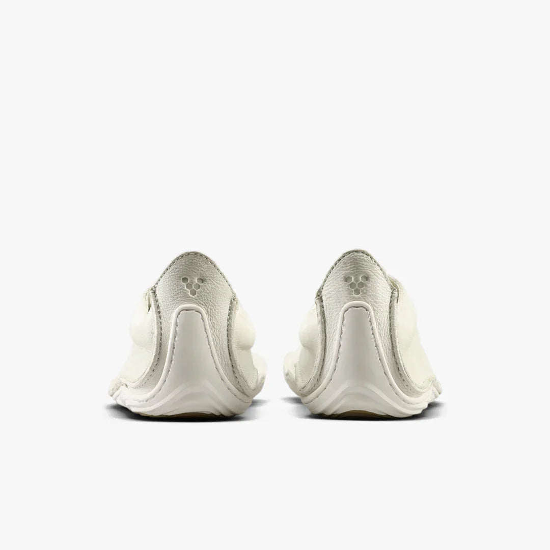 Rear view of white minimalist leather shoes with subtle logo embossed on heel tab