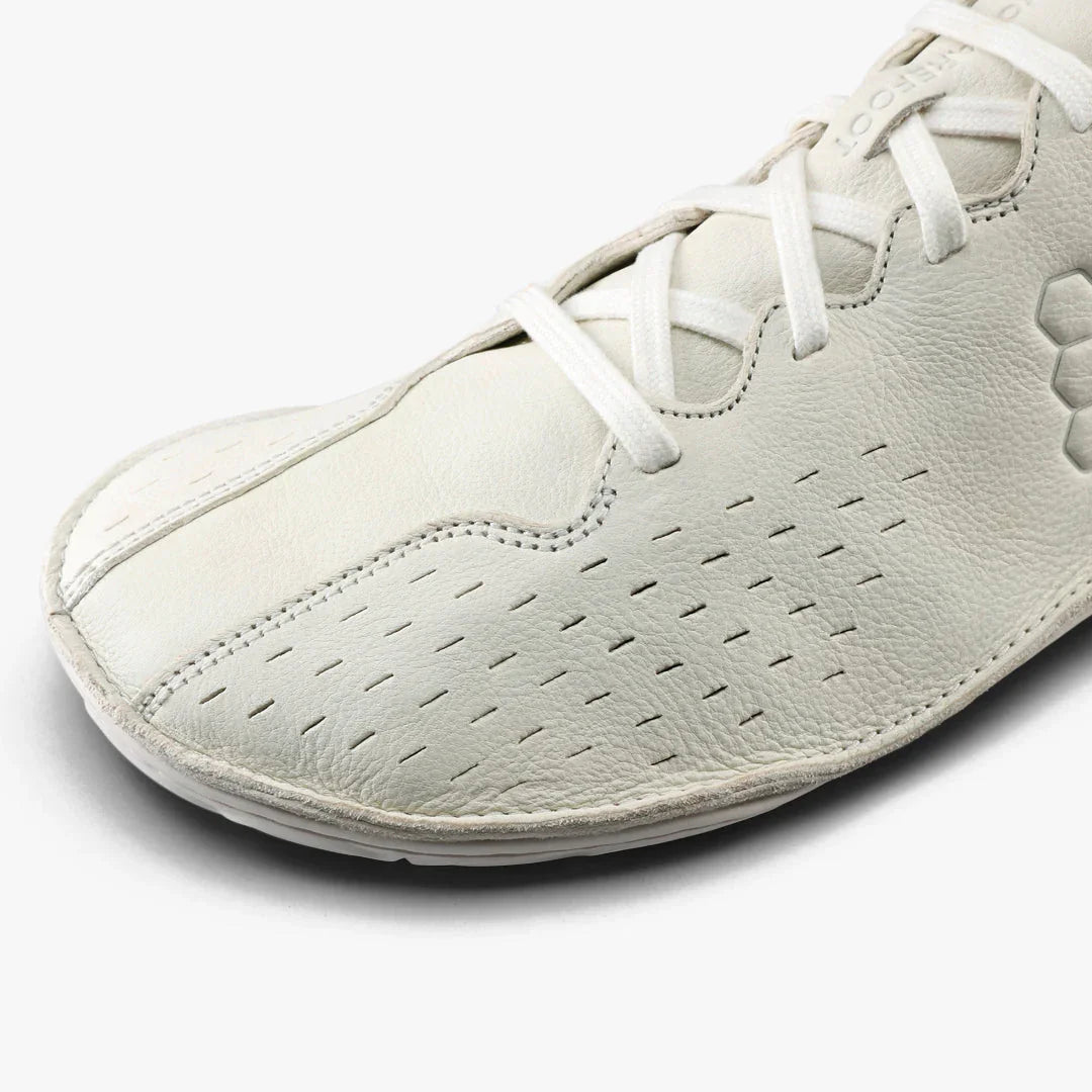 Close-up of white soft leather barefoot shoe with breathable perforations and white laces