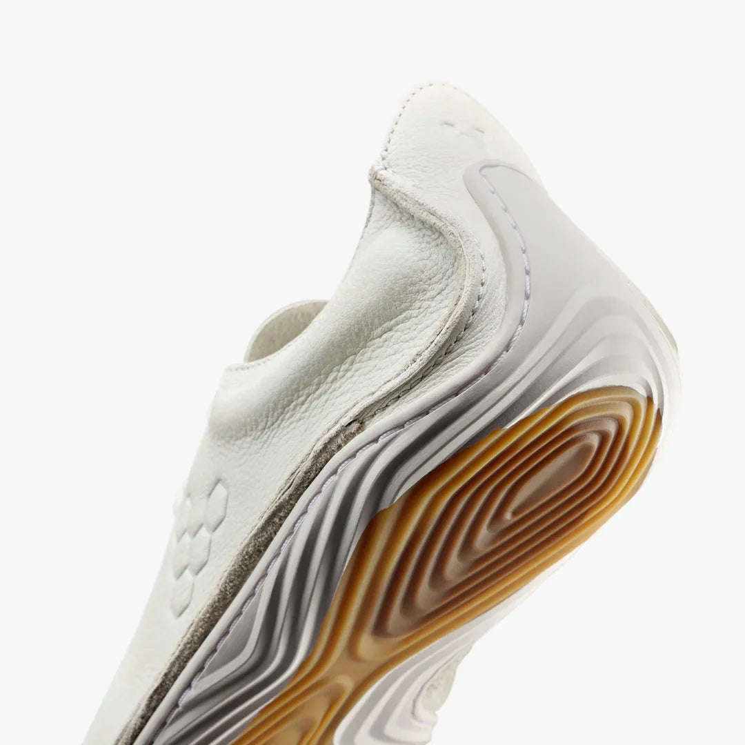 Closeup of white leather sneaker with textured sole in white and gum rubber