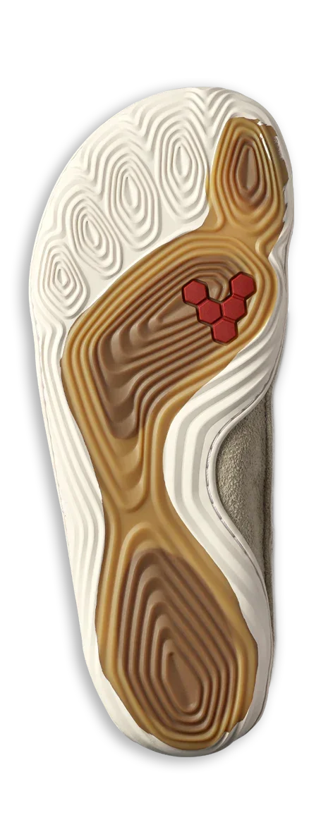 Close-up of a beige and white shoe outsole with textured concentric patterns and red hexagonal accents