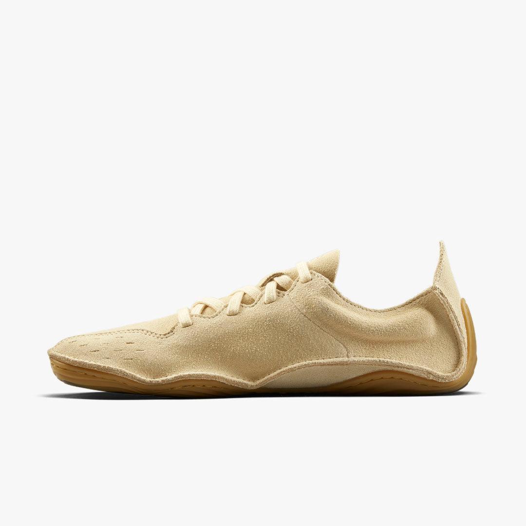 Beige minimalist suede barefoot shoe with low profile, flexible sole, and lace closure