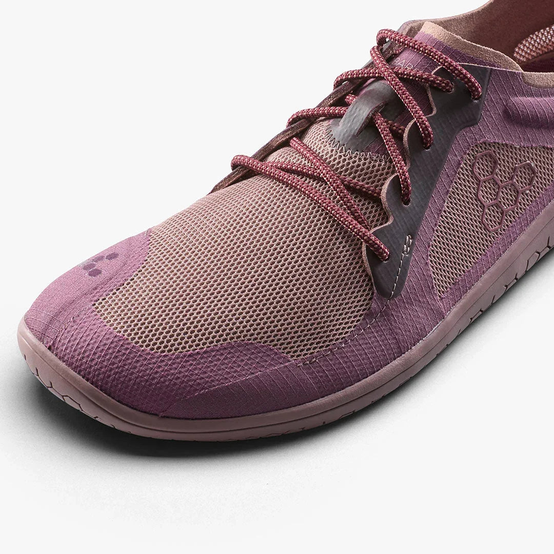 Close-up of a purple and beige lightweight mesh running shoe with textured sole and patterned laces