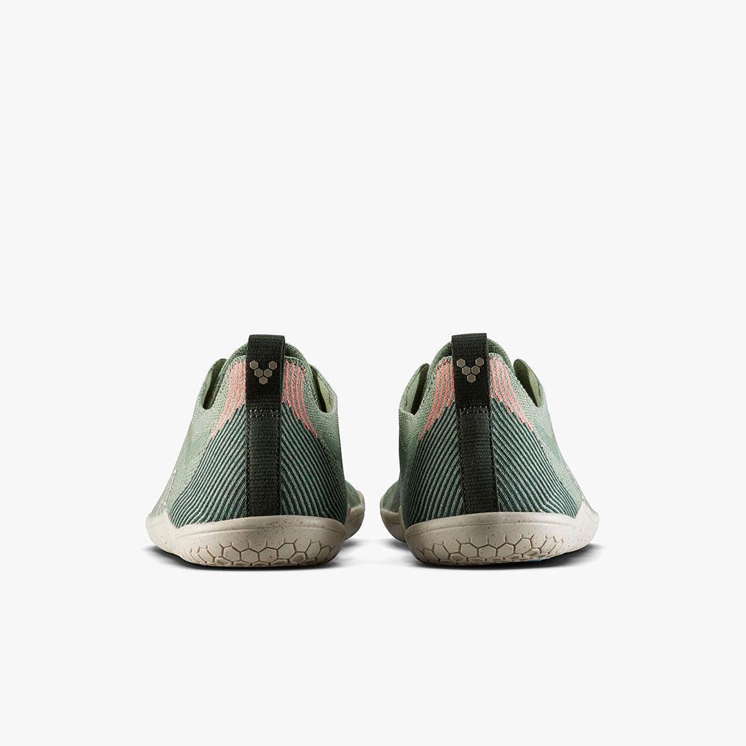 Back view of minimalist green barefoot shoes with textured sole and pull tab on white background