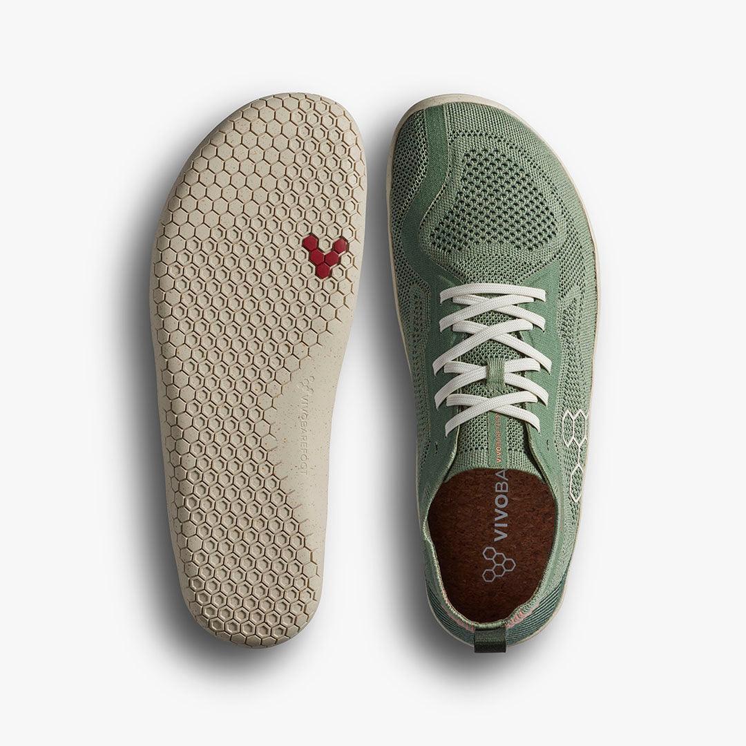 Top view of green Vivobarefoot knit sneaker and beige hex-patterned sole with red accents