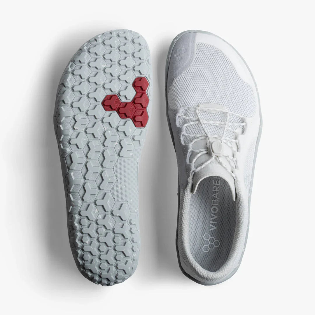White Vivobarefoot minimalist shoe with hexagonal outsole pattern and red hex detail on sole