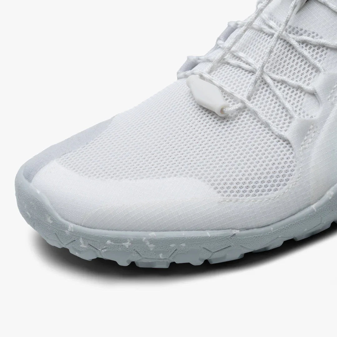 Close-up of white breathable mesh athletic shoe with textured sole and lace lock detail