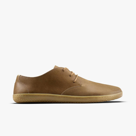 Side view of brown leather casual lace-up shoe with beige rubber sole on white background