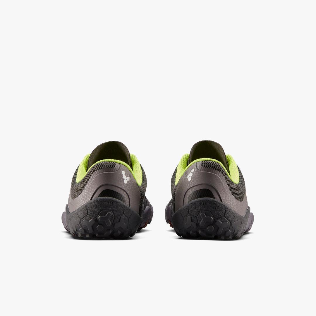 Back view of gray and lime green minimalist running shoes with textured black soles on white background