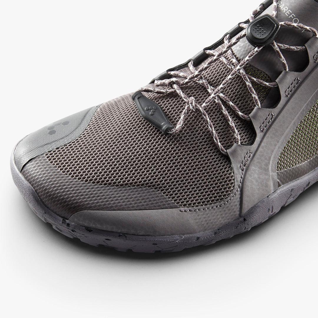 Close-up of a gray barefoot minimalist running shoe with mesh upper and adjustable lace system on white background