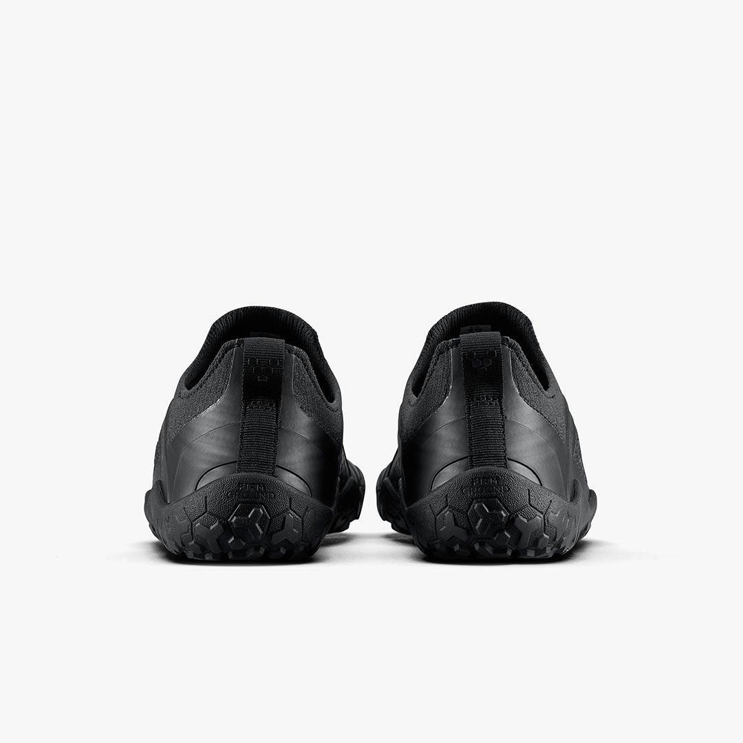 Back view of black sustainable barefoot shoes with textured sole on white background