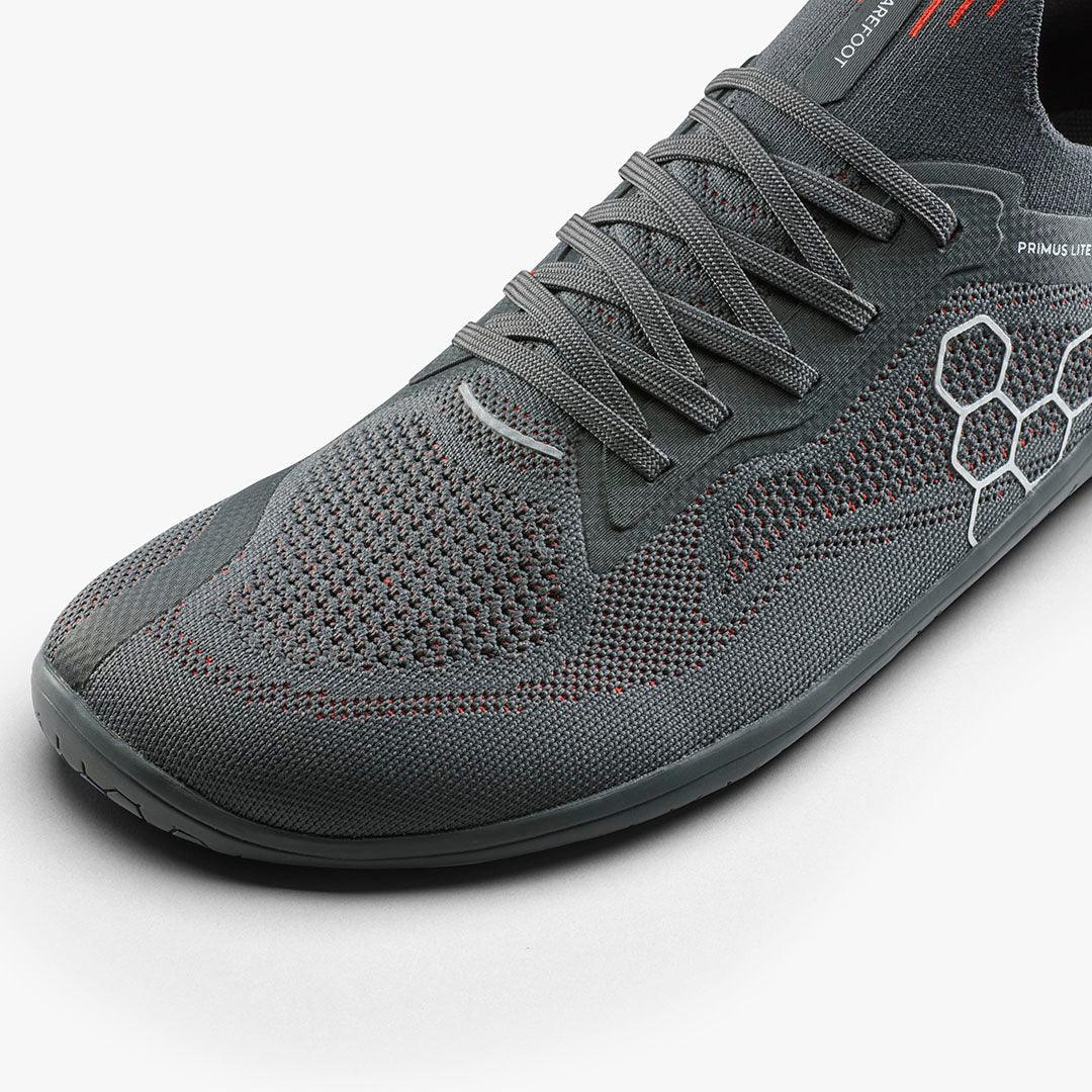 Close-up of gray breathable knit athletic shoe with hexagonal pattern and laces