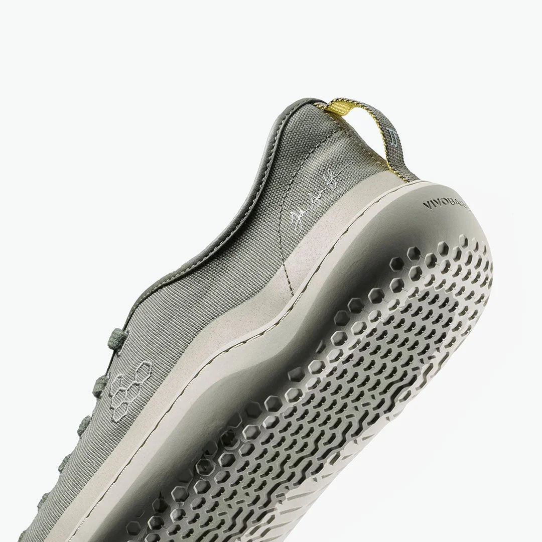 Close-up of grey textile sneaker sole with hexagonal tread pattern and branded heel tab