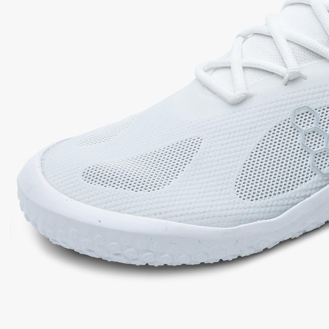 Close-up of white athletic shoe with mesh panels and hexagonal design detail on side