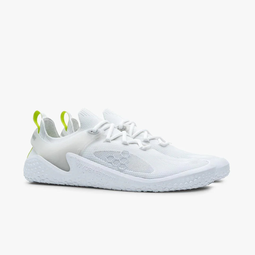 pair of white Vivobarefoot minimalist shoes with green heel loops on light background