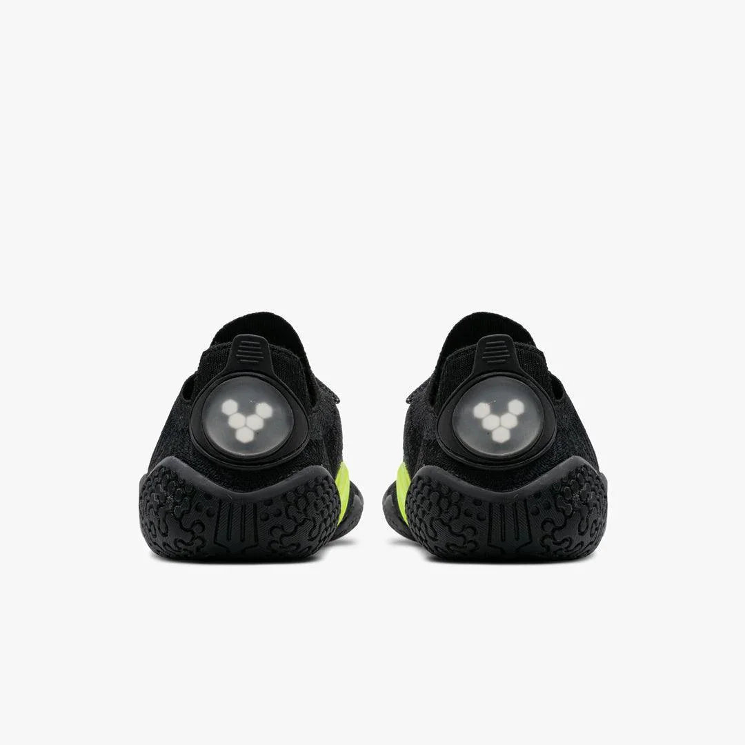 Back view of black athletic shoes with textured soles and a circular logo on the heel