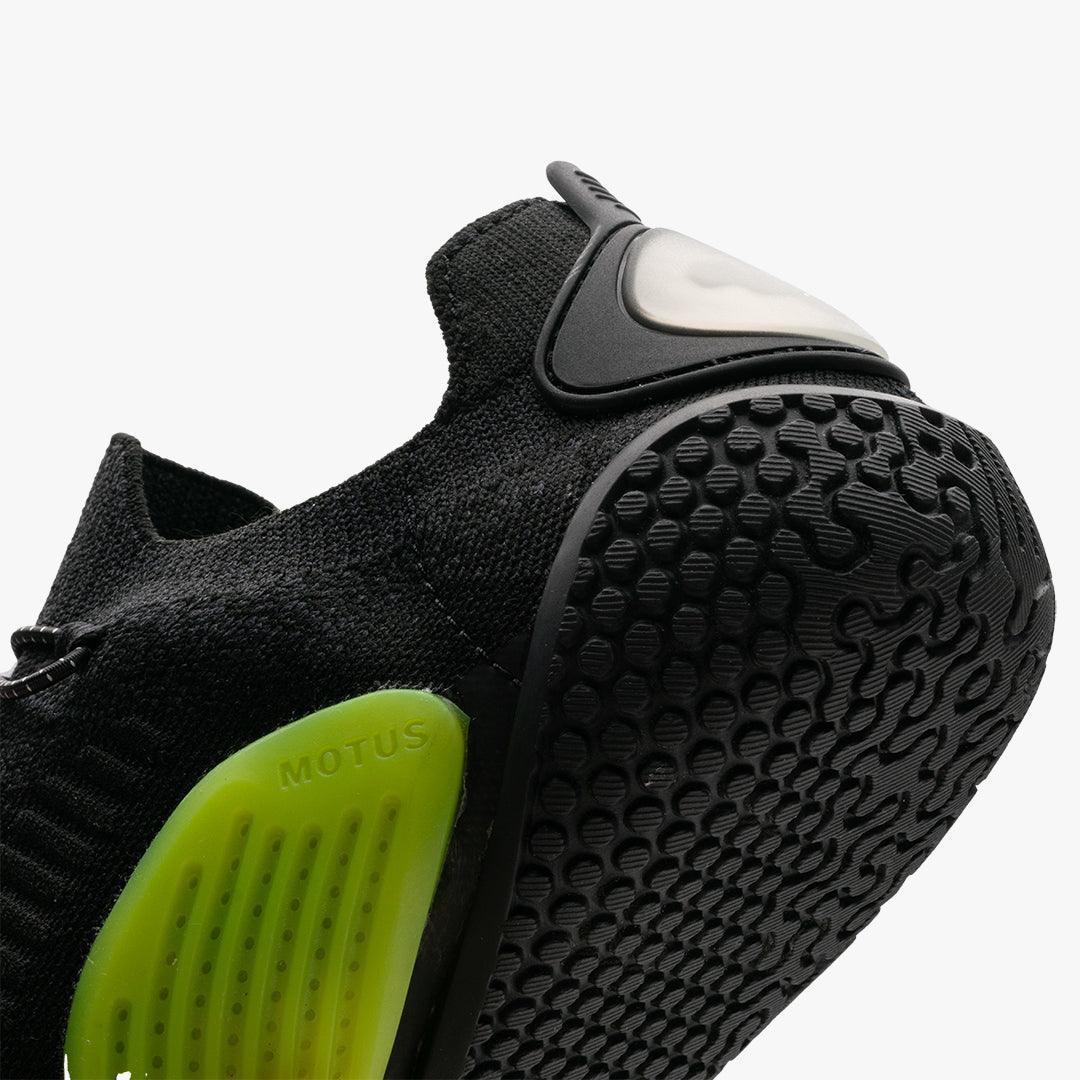 Close-up of black athletic shoe with textured sole and green MOTUS heel support