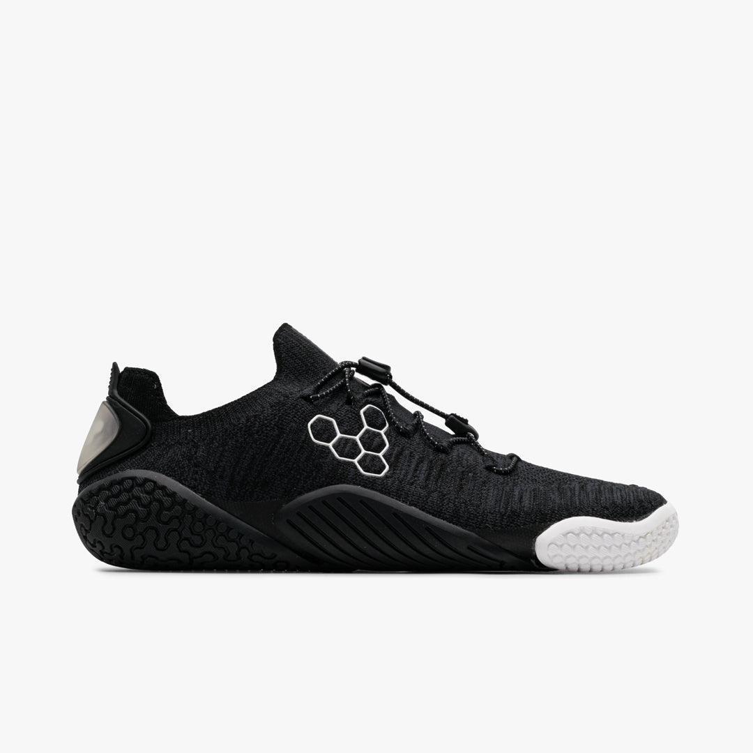 Black knit minimalist athletic shoe with white honeycomb logo and textured sole