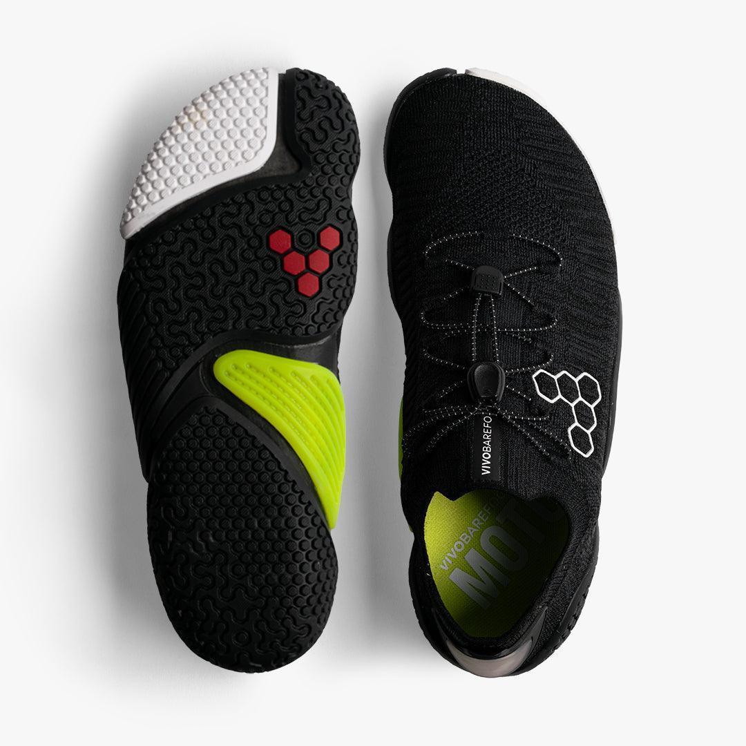 Black VivoBarefoot minimalist running shoes with neon green accents and textured sole against white background