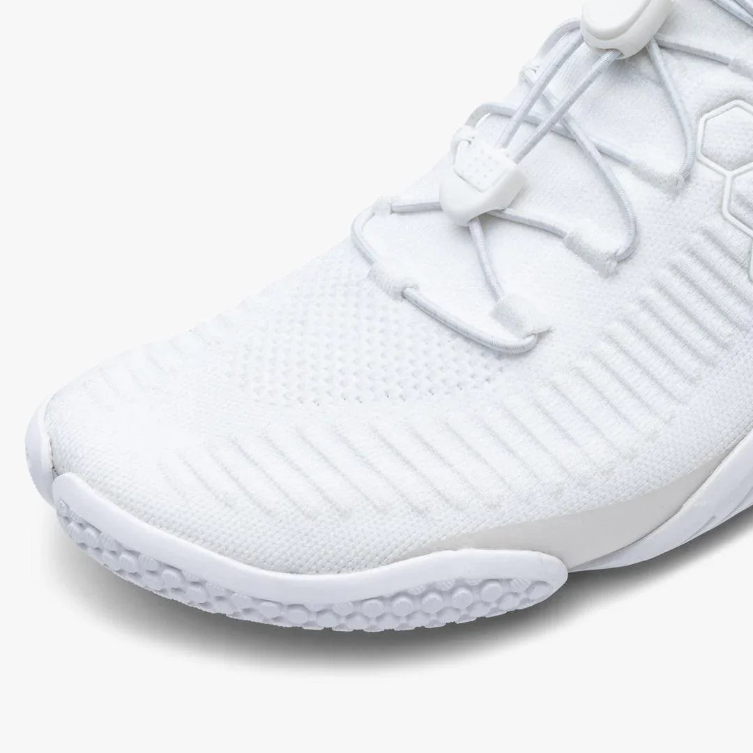 Close-up of white athletic sneaker toe with textured knit fabric and secure lace lock