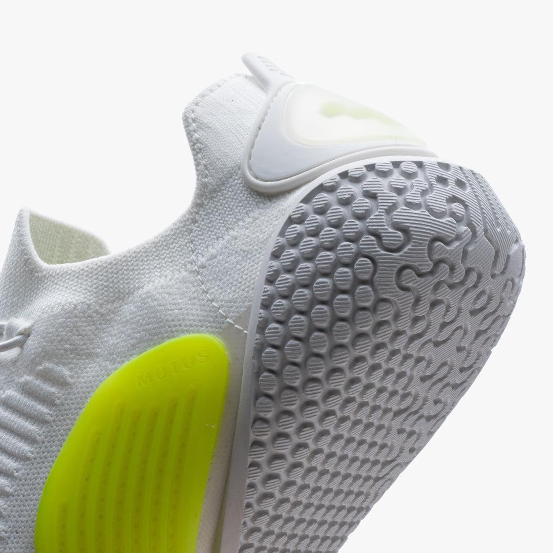 Close-up of white knit sneaker heel with textured sole and neon yellow Motus detail