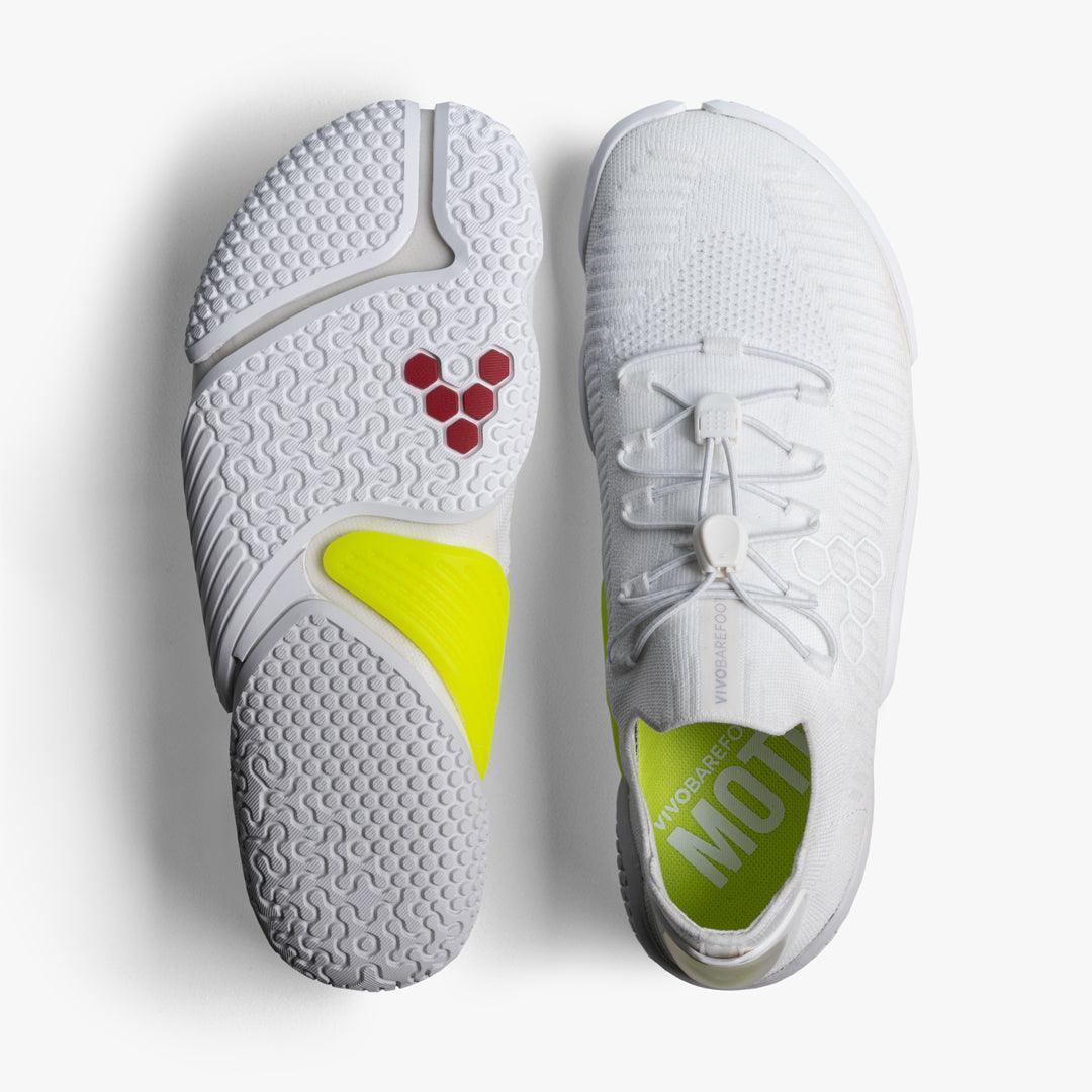 Pair of white Vivobarefoot minimalist running shoes with yellow accents and textured sole
