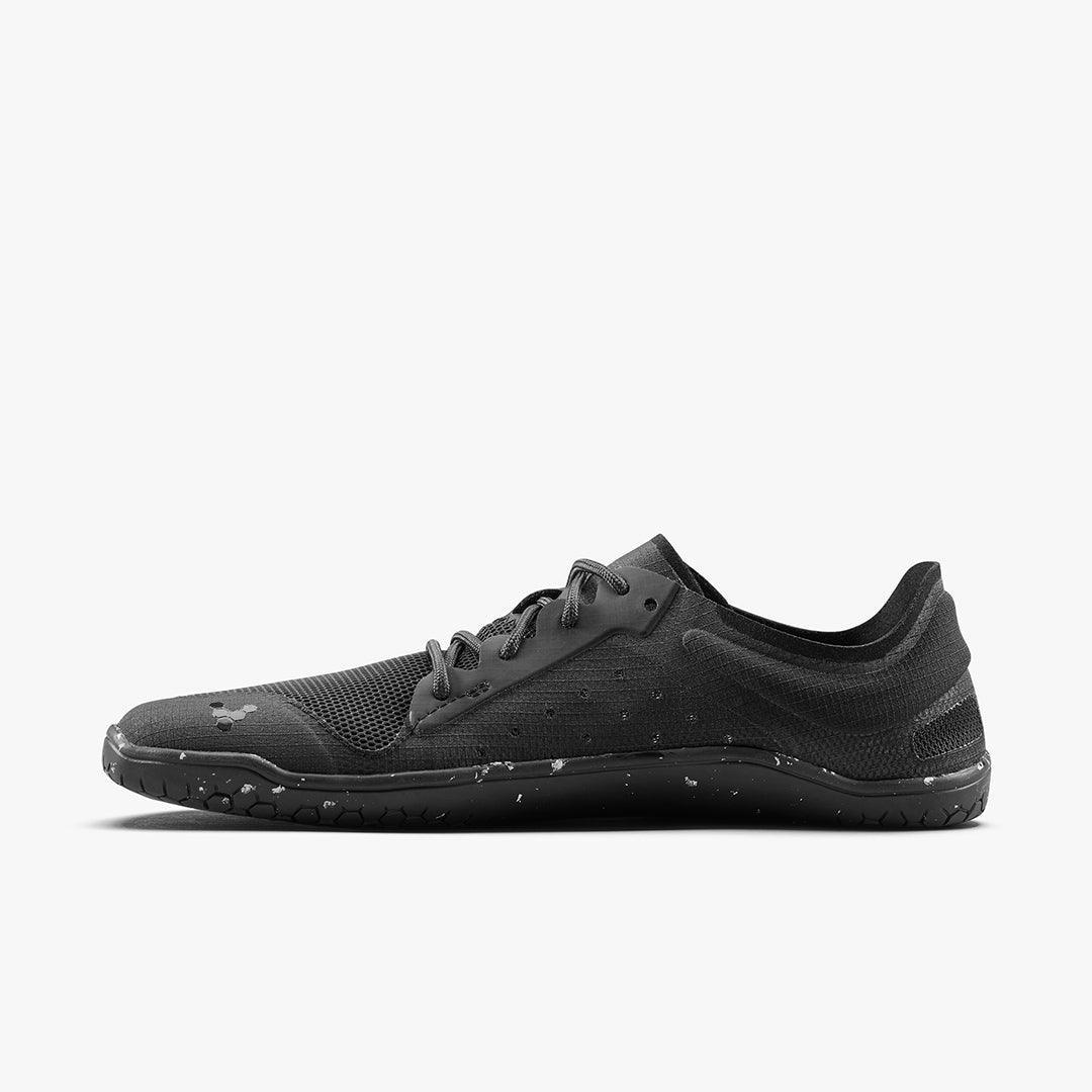 Black minimalist athletic shoe with textured upper and speckled sole on white background