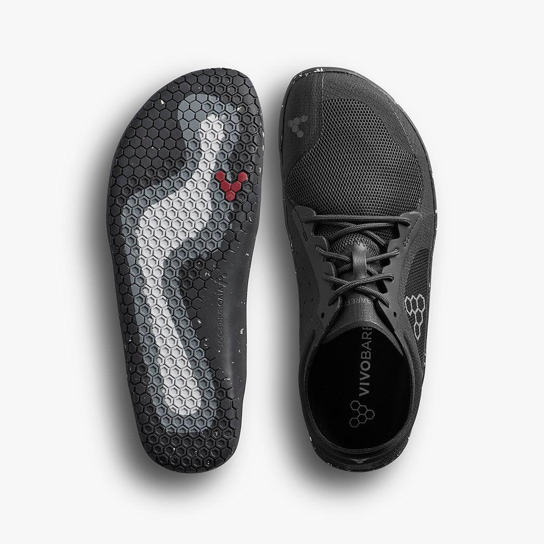 Black Vivobarefoot minimalist shoe and sole with hexagonal pattern and red logo on white background
