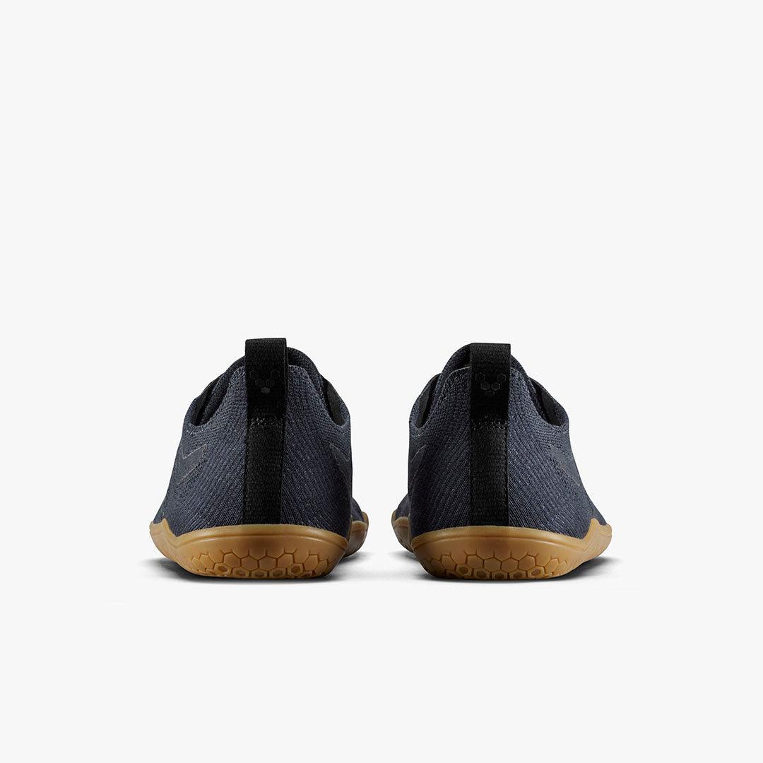 Back view of minimalist dark grey athletic shoes with black heel pull tab and textured gum soles