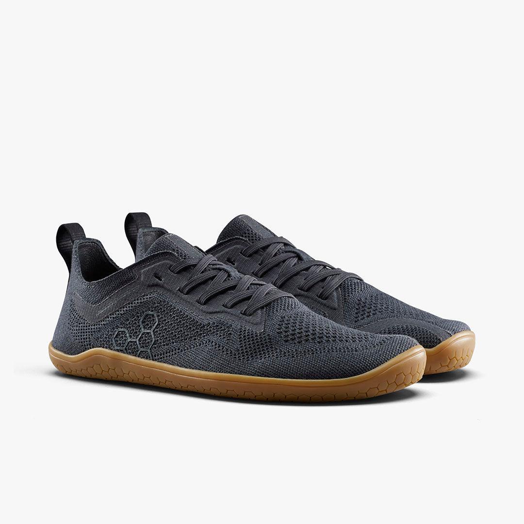 Pair of black lightweight knit sneakers with gum sole and honeycomb pattern on side