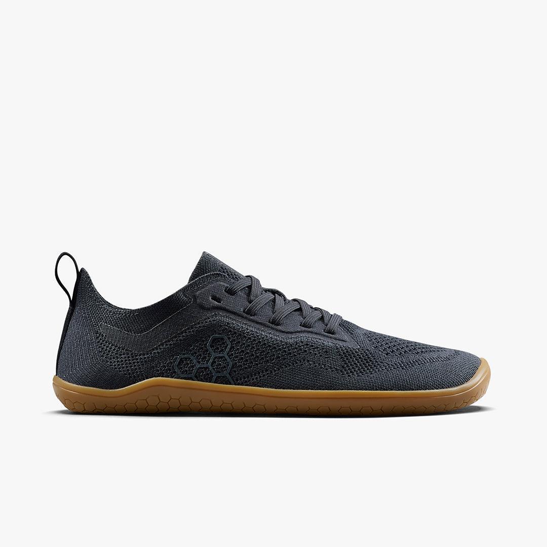 Black lightweight minimalist sneaker with knit upper and gum sole, side view